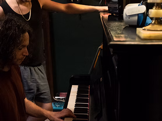 A musician working at a piano inside Sleepless Footscray